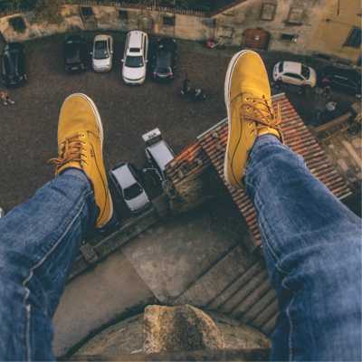 Point of view from a person sitting on top of a building with their feet dangling from the edge.